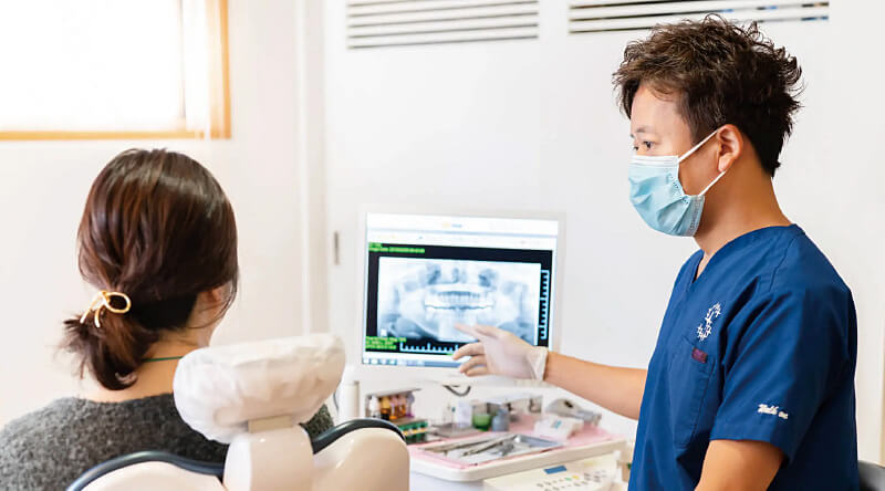 歯科医師が患者にレントゲン画像を説明