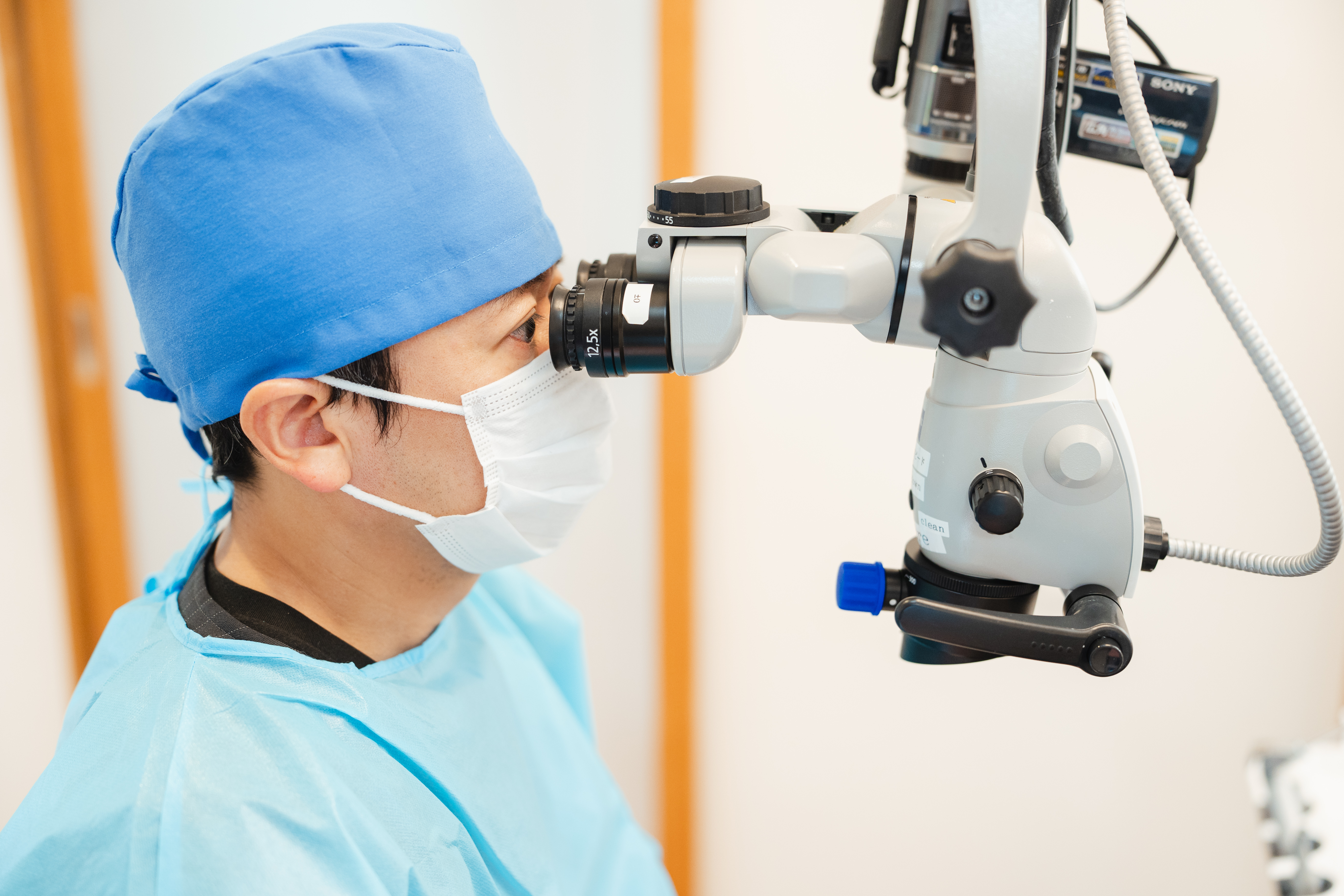 歯科用顕微鏡を覗く男性医師