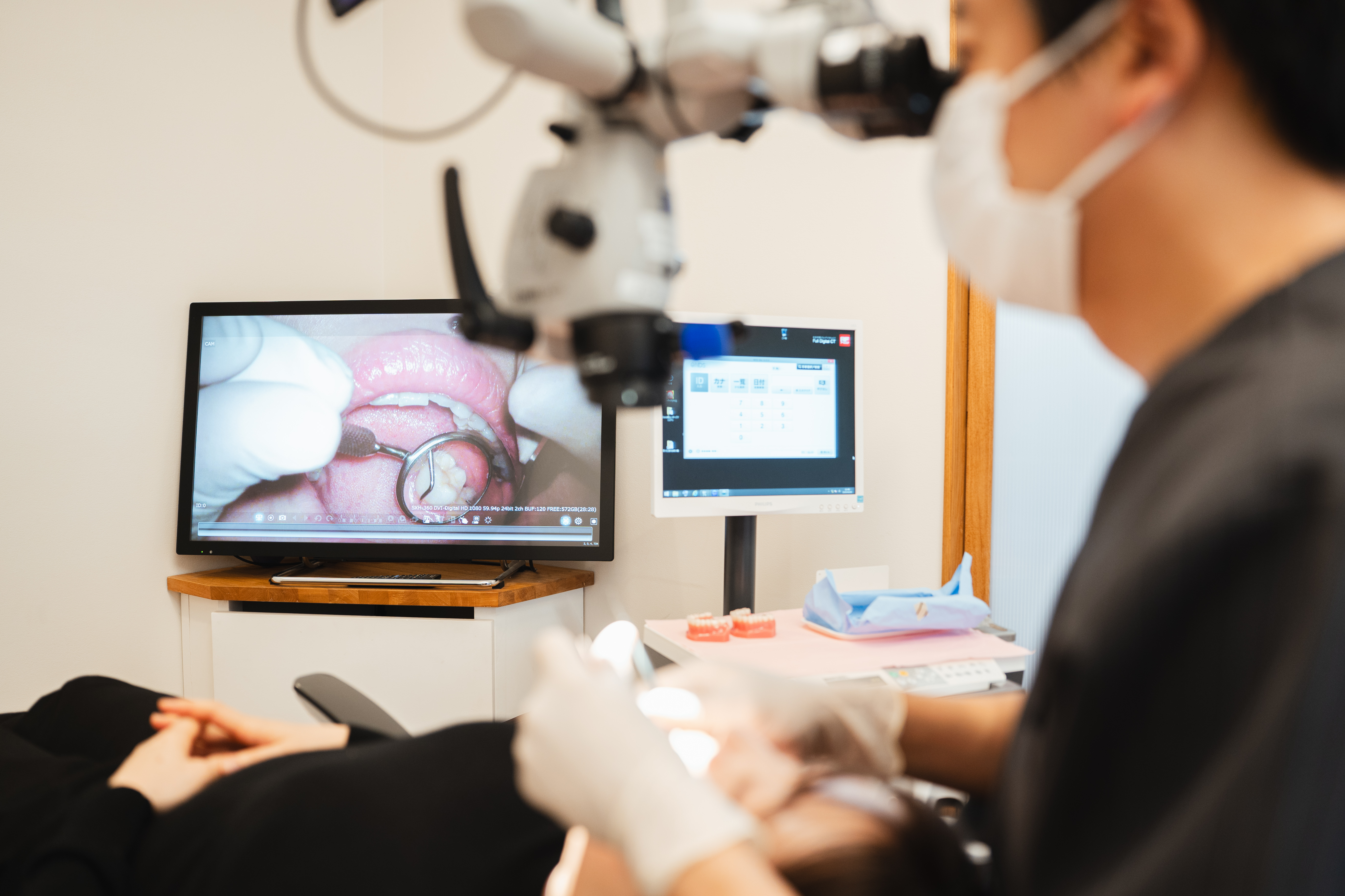 マイクロスコープで歯を確認する歯科医師