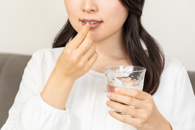 薬を飲む女性
