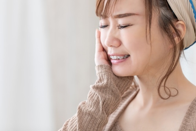 神経を抜いた歯が痛んでいる女性
