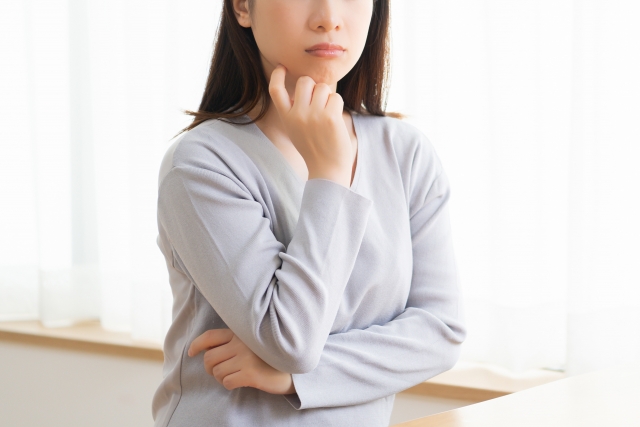 顎に手を当てて考える女性
